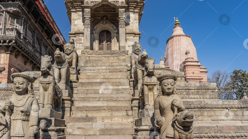 Скачать Красивый древний храм. Вдоль каменных ступеней лестницы расположены скульптуры людей и животных. фотосток Ozero