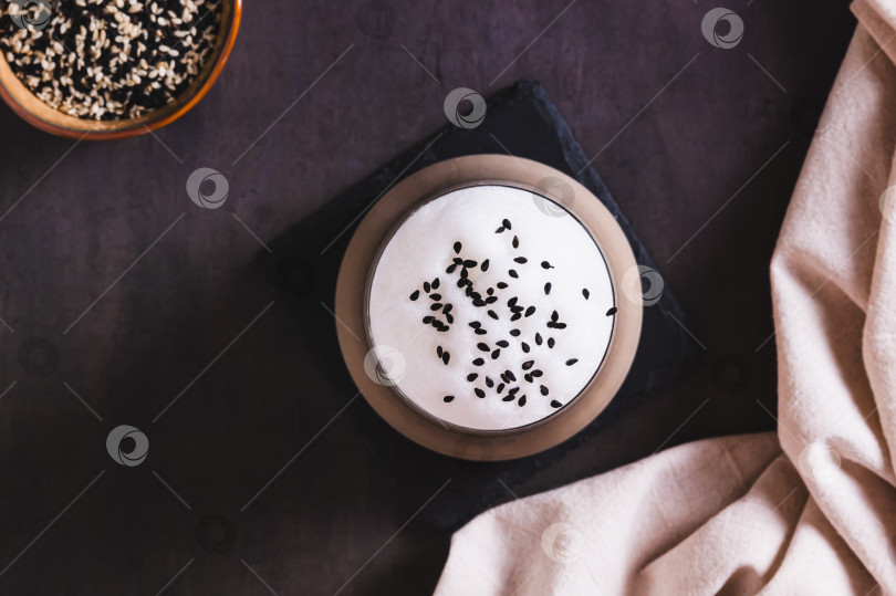 Скачать Крупный план изысканного напитка black sesame latte в бокале на столе вид сверху фотосток Ozero