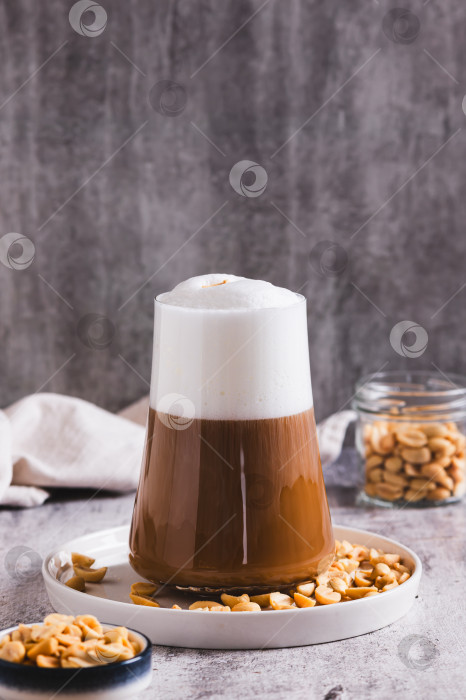 Скачать Изысканный арахисовый раф-кофе в бокале на столе, вид сверху фотосток Ozero