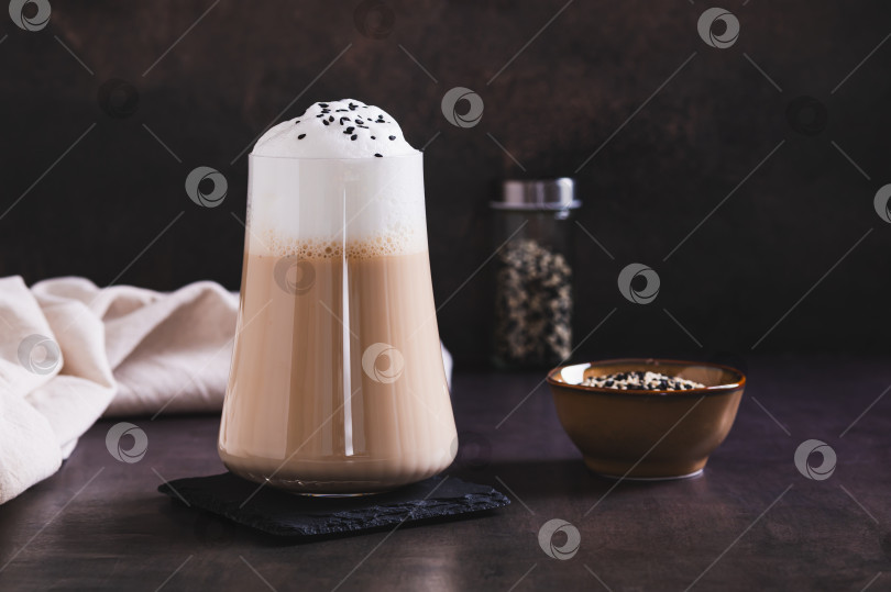 Скачать Изысканный напиток латте с черным кунжутом в бокале на столе фотосток Ozero