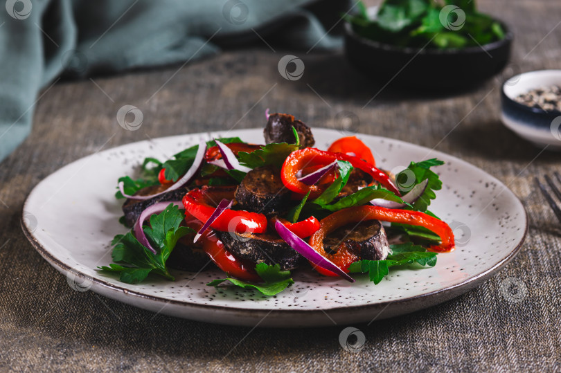 Скачать Теплый салат с жареными баклажанами, болгарским перцем, луком и зеленью на тарелке на стол фотосток Ozero