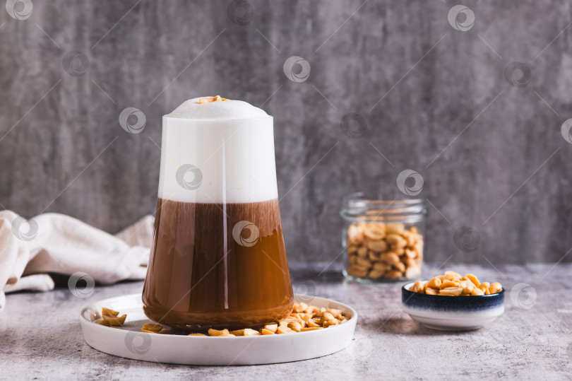Скачать Изысканный арахисовый кофе раф в бокале на столе фотосток Ozero