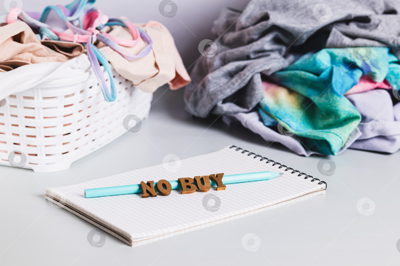 Скачать Блокнот, карандаш, текст и стопки одежды для сортировки на столе фотосток Ozero