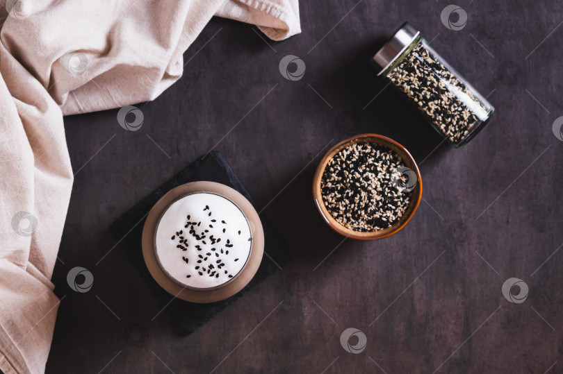 Скачать Изысканный напиток латте с черным кунжутом в бокале на столе вид сверху фотосток Ozero