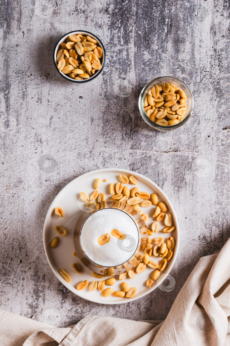 Скачать Вкусный кофе с арахисовым маслом в стакане на столешнице и вертикальном обзоре фотосток Ozero