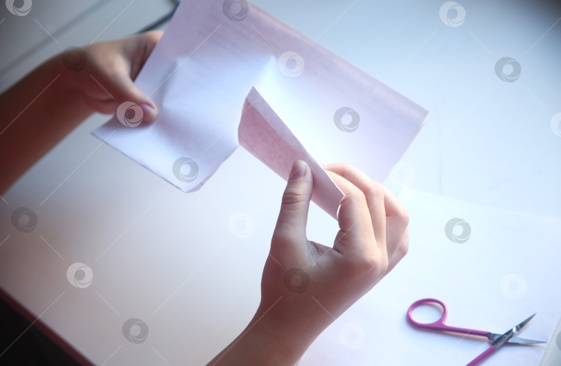 Скачать Девочка разрезает бумагу пополам фотосток Ozero