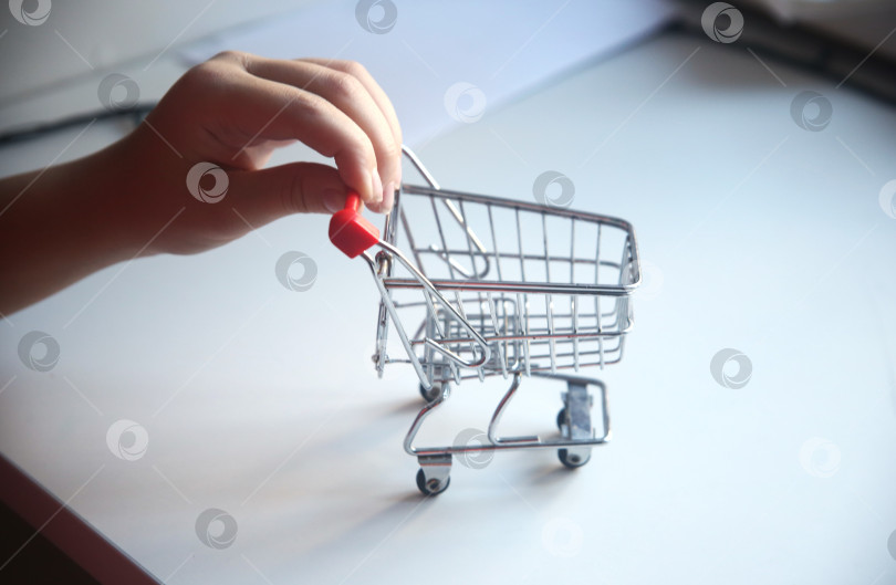 Скачать Маленькая тележка для покупок в детской руке фотосток Ozero