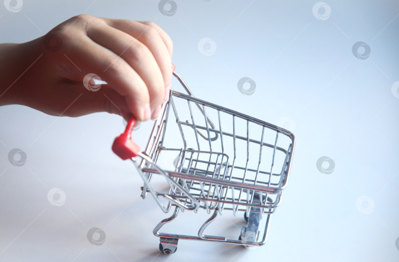 Скачать Маленькая тележка для покупок в детской руке фотосток Ozero