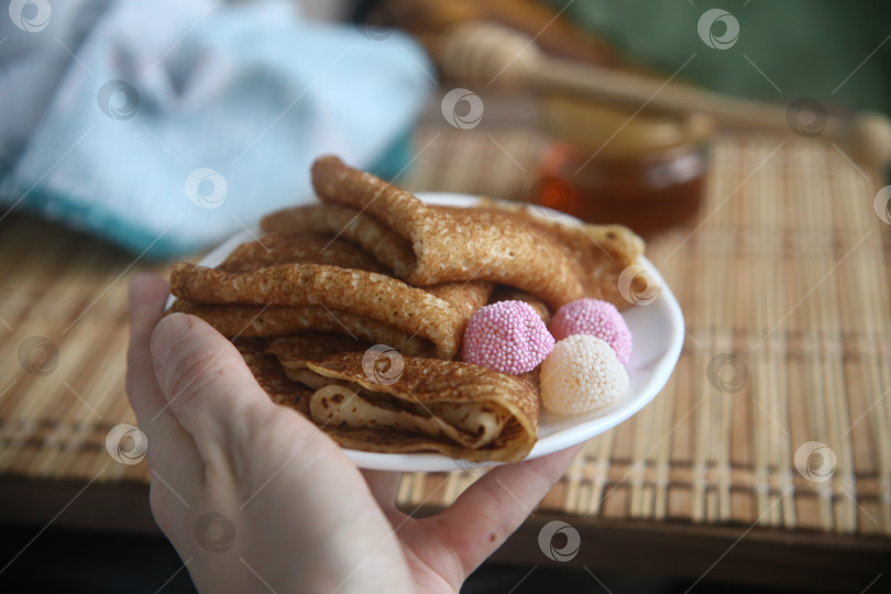 Скачать Румяные и вкусные блины на тарелке в руке фотосток Ozero