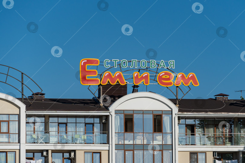 Скачать Название столовой - "Ешь и закусывай" - на здании на набережной реки Мзымта в федеральной земле Сириус. Крупный план. Адлер, Сочи. фотосток Ozero