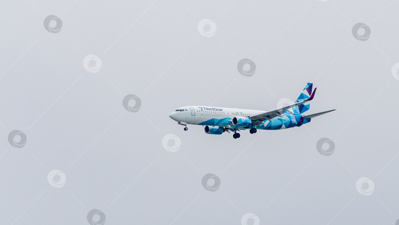Скачать Boeing 737-800 авиакомпании NordStar летит со снижением к взлетно-посадочной полосе на фоне облачного неба. Крупный план. Шасси и закрылки самолета выпущены. фотосток Ozero