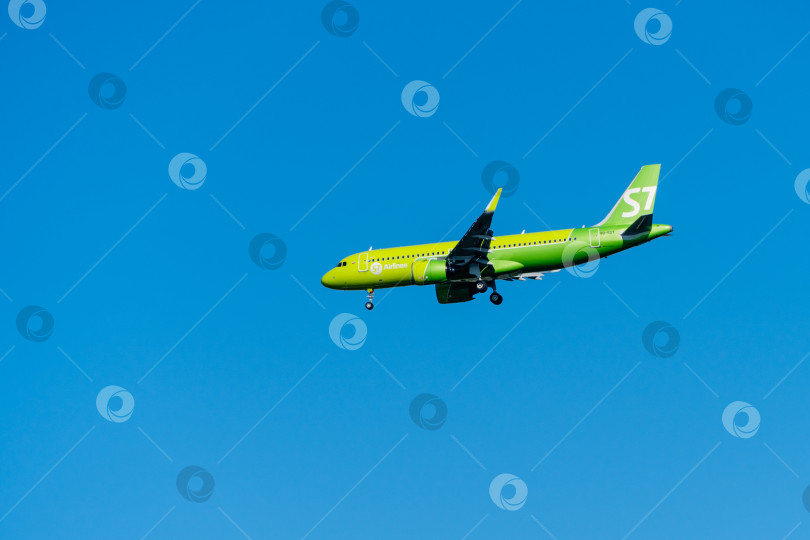 Скачать Airbus A320-271N заходит на взлетно-посадочную полосу аэропорта Адлера на фоне голубого весеннего неба. Авиакомпания S7 Airlines. Крупный план. Шасси и закрылки самолета выпущены. фотосток Ozero