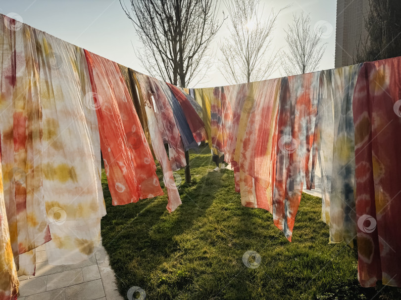 Скачать Сушится одежда на веревке. На веревке развешаны разноцветные платки фотосток Ozero