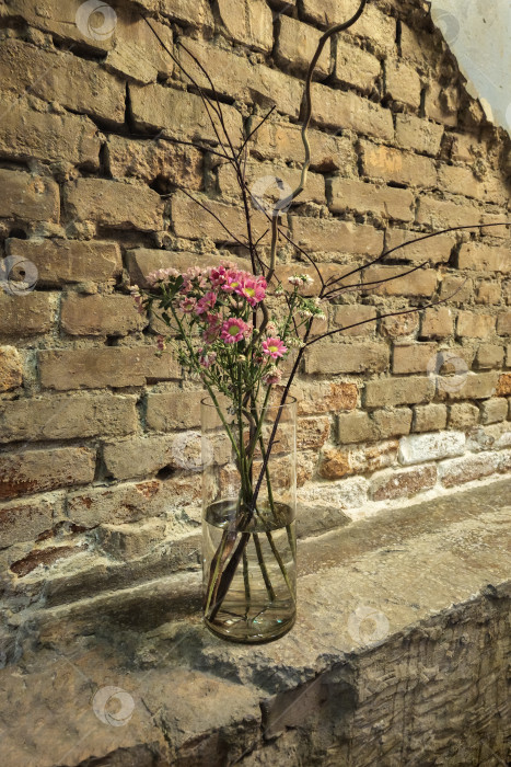 Скачать Вид сверху: ваза с цветами стоит на кирпичной стене. фотосток Ozero