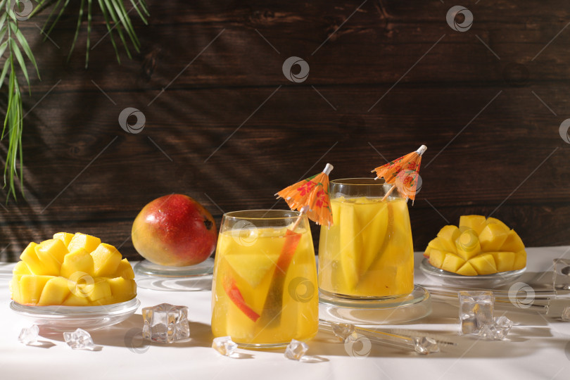 Скачать Замороженный лимонад или сок с кусочками манго, мохито с текилой, лимоном и льдом, концепция бара и вечеринки, рекламная открытка ресторана и кафе, меню ресторана, рекламный баннер домашней вечеринки фотосток Ozero