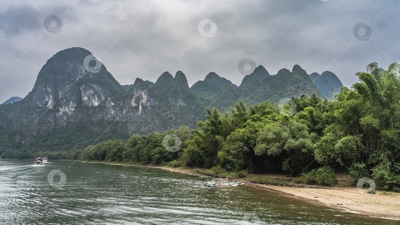 Скачать Живописная река. У берега стоят бамбуковые плоты. фотосток Ozero