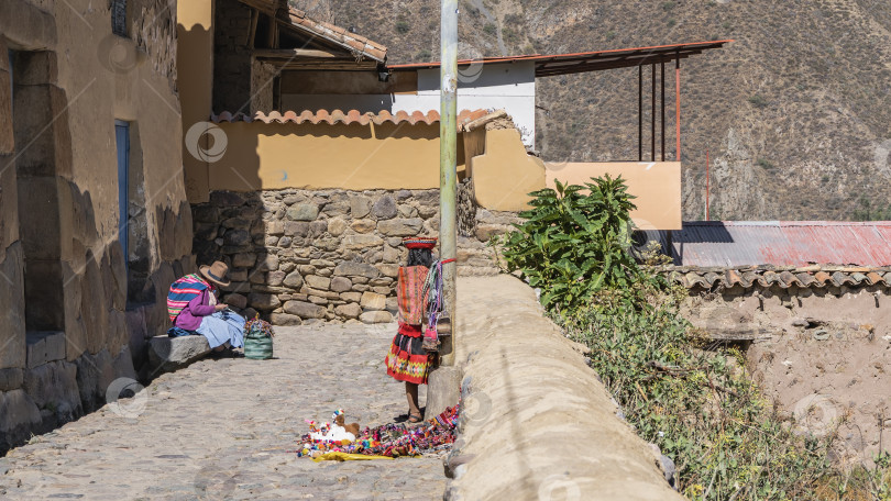 Скачать На мощеной улице старого города выставлены на продажу сувениры. фотосток Ozero