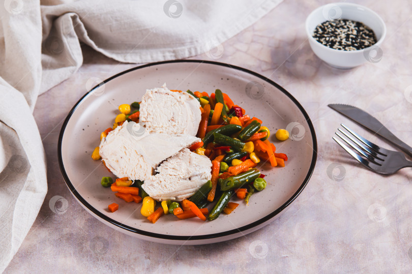 Скачать Куриное филе и мексиканская овощная смесь, приготовленные на пару на тарелке на столе фотосток Ozero