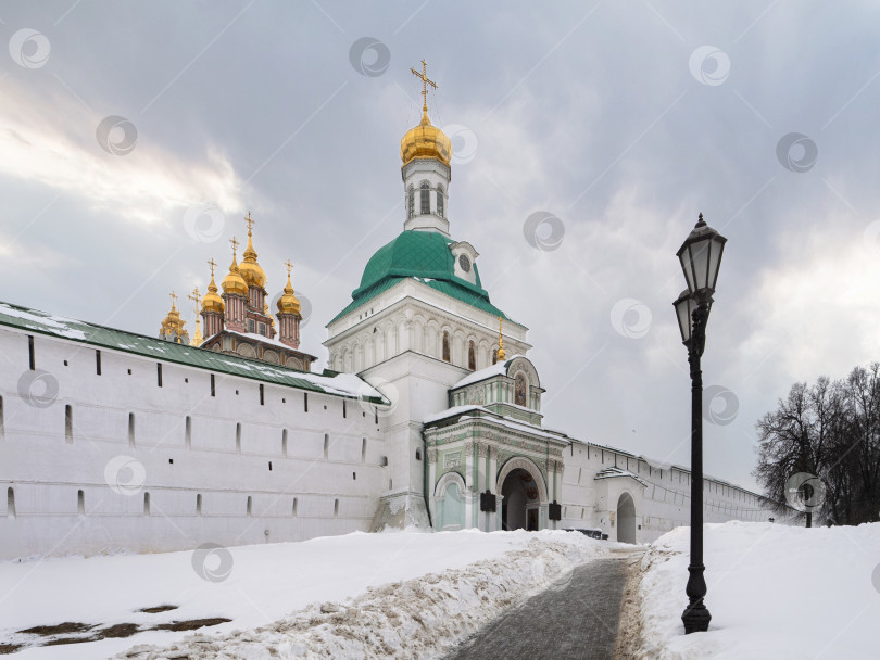 Скачать Вид на Святые врата,  Надвратную церковь и монастырскую стену в ансамбле Свято-Троицкой Сергиевой лавры зимой фотосток Ozero