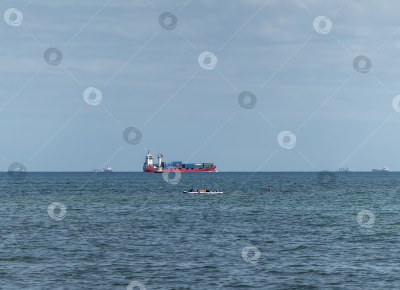 Скачать 24 августа 2025 года: Крупное грузовое судно заходит в порт Новороссийска, Россия, на Черном море, демонстрируя морской транспорт, промышленное судоходство и береговую инфраструктуру. фотосток Ozero