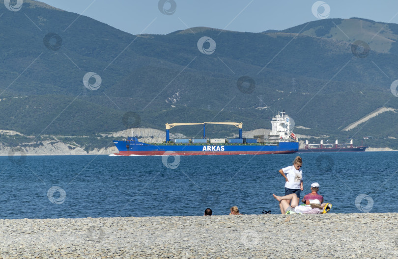 Скачать 24 августа 2025 года: Крупное грузовое судно заходит в порт Новороссийска, Россия, на Черном море, демонстрируя морской транспорт, промышленное судоходство и береговую инфраструктуру. фотосток Ozero