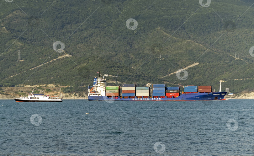 Скачать 24 августа 2025 года: Крупное грузовое судно заходит в порт Новороссийска, Россия, на Черном море, демонстрируя морской транспорт, промышленное судоходство и береговую инфраструктуру. фотосток Ozero