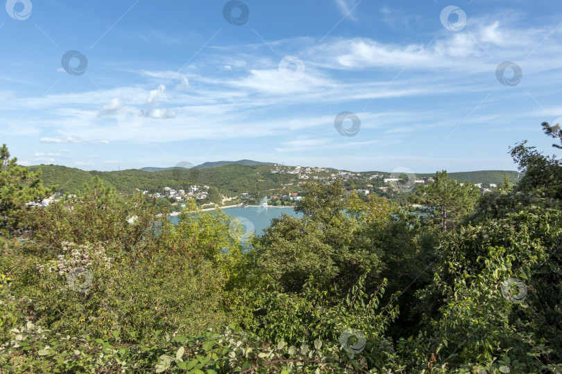 Скачать Набережная вдоль озера Абрау-Дюрсо со спокойной водой, зеленью и живописными окрестностями фотосток Ozero