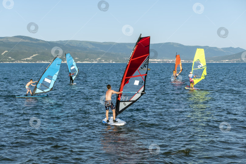 Скачать 24 августа 2025 года: Спортсмен занимается виндсерфингом на море недалеко от Новороссийска, Россия, с парусной доской и волнами, демонстрируя водные виды спорта, активный образ жизни и отдых на побережье. фотосток Ozero