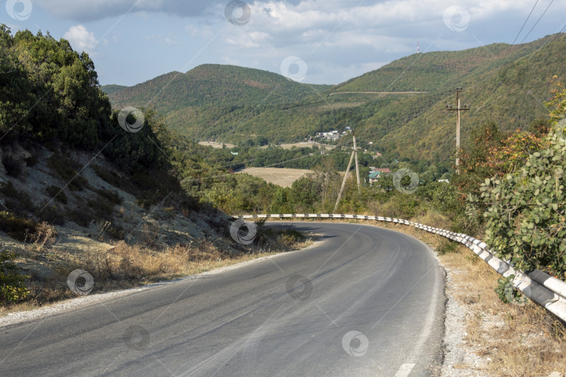 Скачать Асфальтированная горная дорога-серпантин в районе Дюрсо, петляющая по холмам и природному ландшафту, представляет собой туристические, транспортные и живописные горные маршруты фотосток Ozero