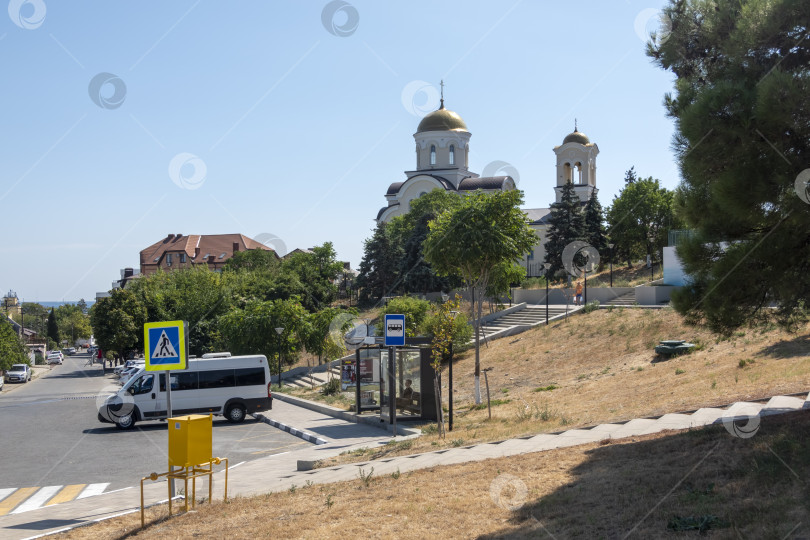 Скачать 24 августа 2025 года: Центральная площадь Мысхако, Россия, с остановкой микроавтобусов и инфраструктурой общественного транспорта, демонстрирующая повседневную городскую жизнь, мобильность и прибрежную городскую среду. фотосток Ozero