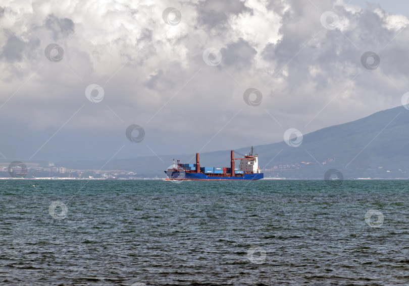 Скачать 24 августа 2025 года: Крупное грузовое судно заходит в порт Новороссийска, Россия, на Черном море, демонстрируя морской транспорт, промышленное судоходство и береговую инфраструктуру. фотосток Ozero