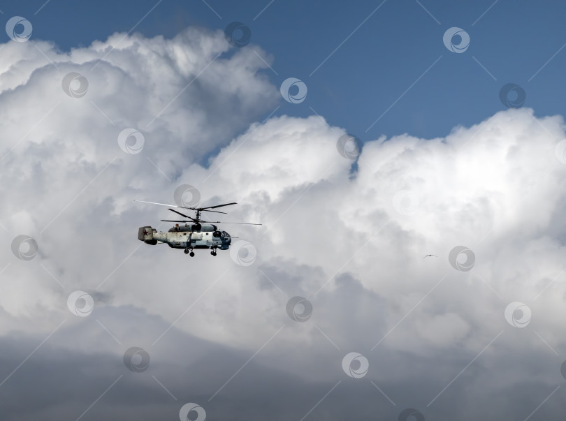Скачать 21 августа 2025 года: Новороссийск, Россия: военный вертолет Ка-27 летит в небе на фоне облаков, демонстрируя действия морской авиации, воздушного патрулирования и обороны на побережье Черного моря. фотосток Ozero