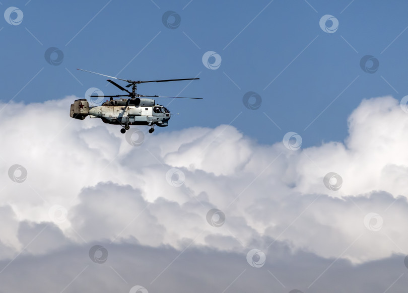 Скачать 21 августа 2025 года: Новороссийск, Россия: военный вертолет Ка-27 летит в небе на фоне облаков, демонстрируя действия морской авиации, воздушного патрулирования и обороны на побережье Черного моря. фотосток Ozero