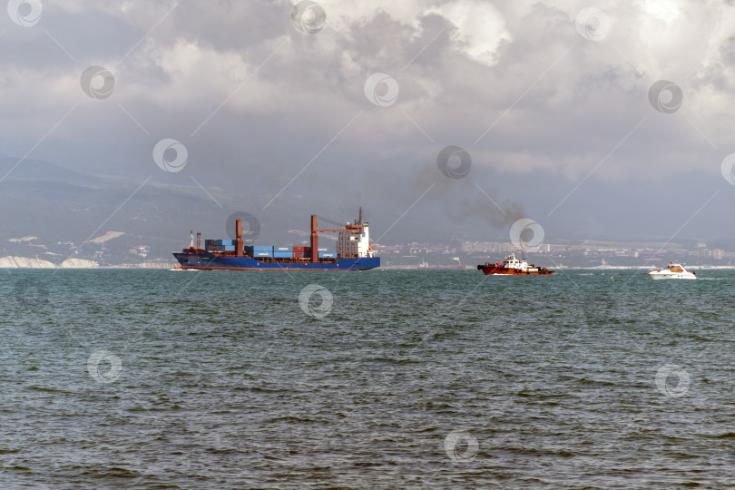 Скачать 24 августа 2025 года: Крупное грузовое судно заходит в порт Новороссийска, Россия, на Черном море, демонстрируя морской транспорт, промышленное судоходство и береговую инфраструктуру. фотосток Ozero