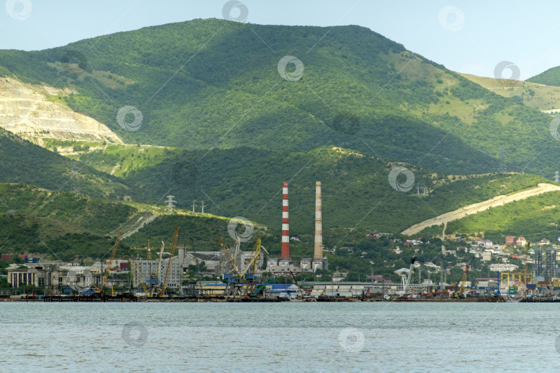 Скачать 22 августа 2025 года, вид порта Новороссийск, Россия, с грузовыми судами и кранами на побережье. Промышленный морской пейзаж на Черном море фотосток Ozero