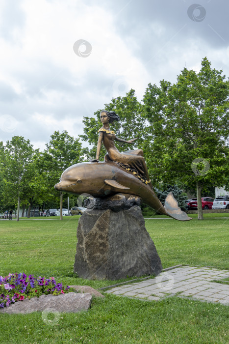 Скачать 28 июля 2025 года: Скульптура девушки на дельфине на набережной в Новороссийске, Россия, популярная приморская достопримечательность, символизирующая прибрежный город и атмосферу Черного моря. фотосток Ozero