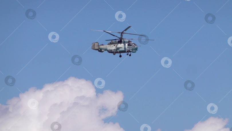 Скачать 21 августа 2025 года: Новороссийск, Россия: военный вертолет Ка-27 летит в небе на фоне облаков, демонстрируя действия морской авиации, воздушного патрулирования и обороны на побережье Черного моря. фотосток Ozero