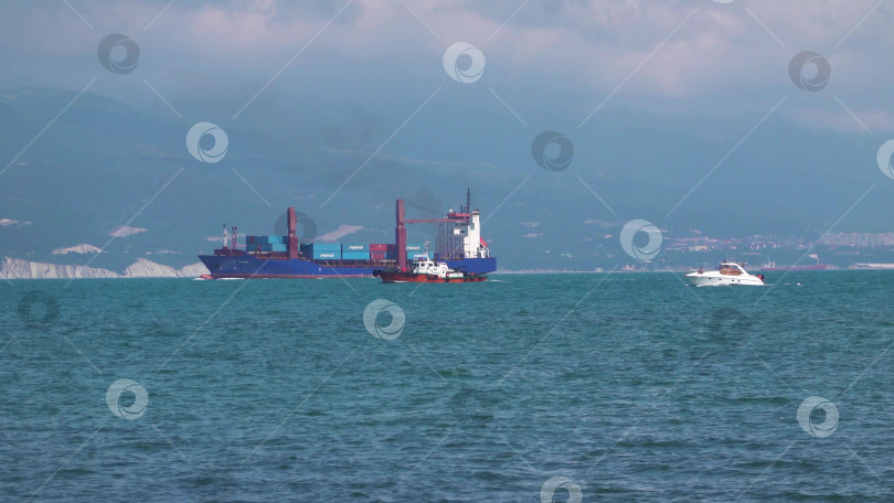 Скачать 24 августа 2025 года: Крупное грузовое судно заходит в порт Новороссийска, Россия, на Черном море, демонстрируя морской транспорт, промышленное судоходство и береговую инфраструктуру. фотосток Ozero