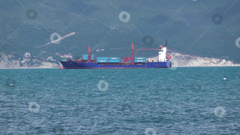 Скачать 24 августа 2025 года: Крупное грузовое судно заходит в порт Новороссийска, Россия, на Черном море, демонстрируя морской транспорт, промышленное судоходство и береговую инфраструктуру. фотосток Ozero