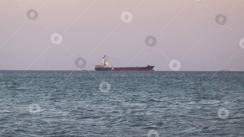 Скачать 24 августа 2025 года: Крупное грузовое судно заходит в порт Новороссийска, Россия, на Черном море, демонстрируя морской транспорт, промышленное судоходство и береговую инфраструктуру. фотосток Ozero