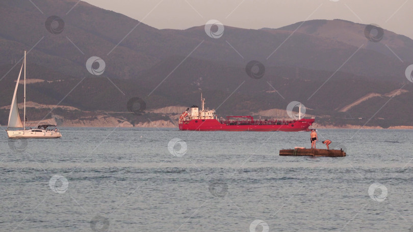 Скачать 24 августа 2025 года: Крупное грузовое судно заходит в порт Новороссийска, Россия, на Черном море, демонстрируя морской транспорт, промышленное судоходство и береговую инфраструктуру. фотосток Ozero