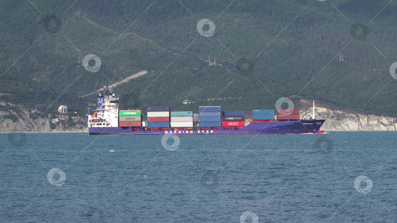 Скачать 24 августа 2025 года: Крупное грузовое судно заходит в порт Новороссийска, Россия, на Черном море, демонстрируя морской транспорт, промышленное судоходство и береговую инфраструктуру. фотосток Ozero