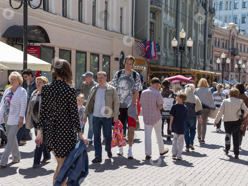 Скачать 14 июля 2022 года: Высокий баскетболист прогуливается по Старому Арбату в Москве, Россия, в наушниках, представляя городской образ жизни, спортивную культуру и повседневную городскую жизнь фотосток Ozero