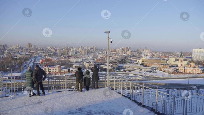 Скачать 28 декабря 2025 года, Барнаул, Россия. Зимой люди прогуливаются по центральной городской аллее, наслаждаясь заснеженными городскими улицами, сезонными мероприятиями на свежем воздухе и городским пейзажем. фотосток Ozero