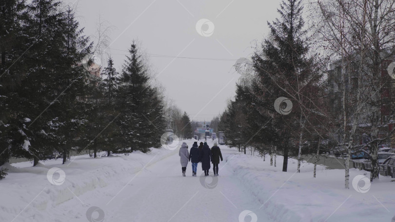 Скачать 28 декабря 2025 года, Барнаул, Россия. Зимой люди прогуливаются по центральной городской аллее, наслаждаясь заснеженными городскими улицами, сезонными мероприятиями на свежем воздухе и городским пейзажем. фотосток Ozero