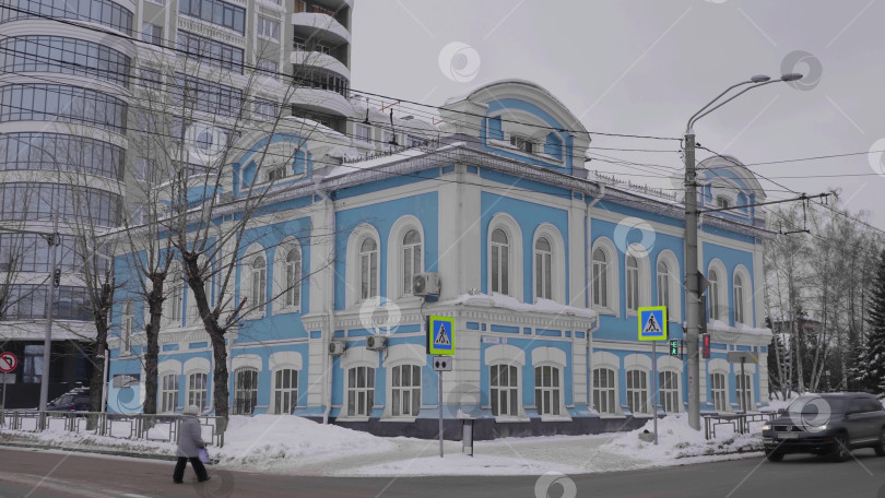 Скачать 28 декабря 2025 года, Барнаул, Россия. Здание ЗАГСА, демонстрирующее внешнюю архитектуру, городской пейзаж и заснеженный город. фотосток Ozero
