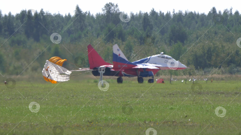 Скачать 25 июля 2021 года, Россия, Жуковский. Российская пилотажная группа "Стрижи" на реактивных самолетах МиГ-29 совершает посадку с помощью парашютов на авиасалоне МАКС-2021, демонстрируя точность пилотажа и военную авиацию. фотосток Ozero