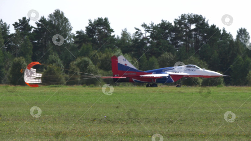 Скачать 25 июля 2021 года, Россия, Жуковский. Российская пилотажная группа "Стрижи" на реактивных самолетах МиГ-29 совершает посадку с помощью парашютов на авиасалоне МАКС-2021, демонстрируя точность пилотажа и военную авиацию. фотосток Ozero