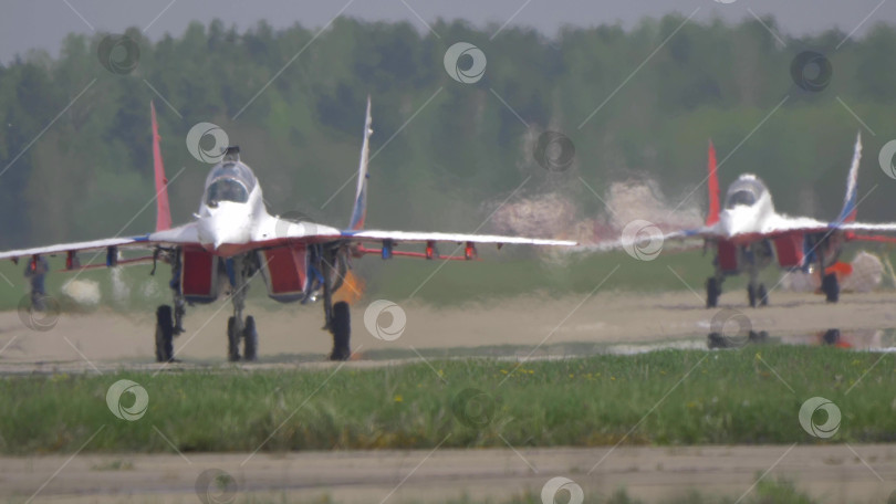 Скачать 25 июля 2021 года, Россия, Жуковский. Российская пилотажная группа "Стрижи" на реактивных самолетах МиГ-29 приземляется с помощью парашютов на авиасалоне МАКС-2021, демонстрируя точность пилотажа и военную авиацию. фотосток Ozero