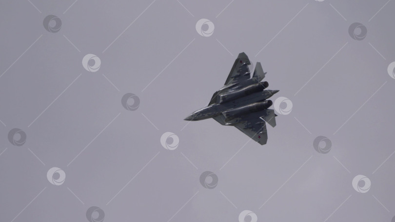 Скачать 25 июля 2021 года, Россия, Жуковский. Истребитель Су-57 выполняет фигуры высшего пилотажа на авиасалоне МАКС-2021, демонстрируя современную военную авиацию, точность пилотажа и летно-технические характеристики самолета. фотосток Ozero